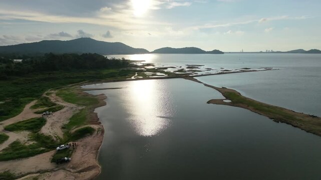 Aerial drone footage of a calm lake reflecting clouds and mountains at sunset light. Ideal for nature, travel, environment, wetland, and cinematic landscape projects.