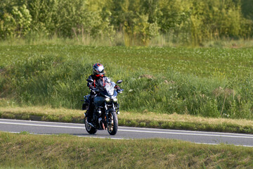Obraz premium Motorcyclist enjoys a summer ride on the highway