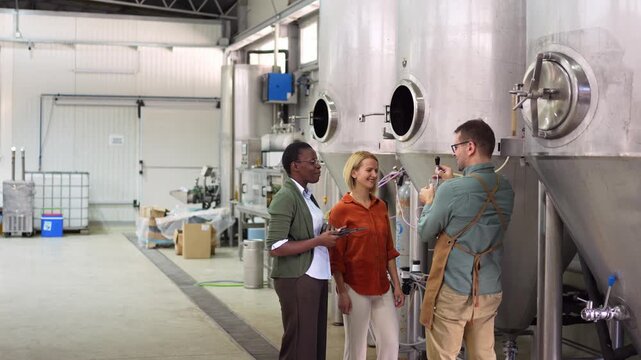 Master brewer explaining the fermentation process to business partners