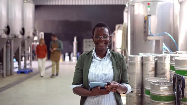 African American female inspector smiling in a modern brewery