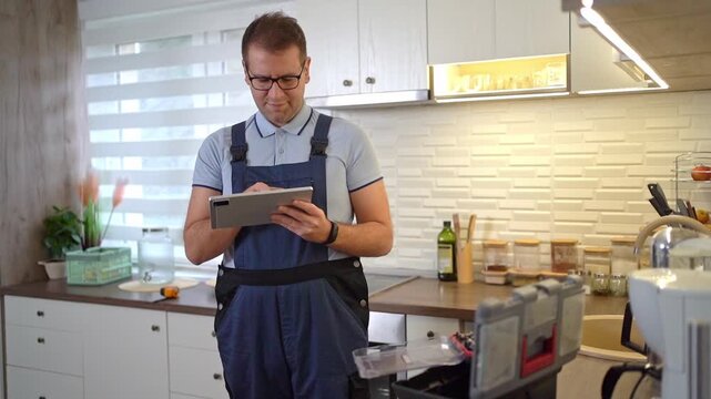 Handyman using a digital tablet in a kitchen