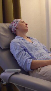 Woman receiving cancer therapy while seated comfortably in treatment center, healthcare recovery scene highlighting perseverance, healing