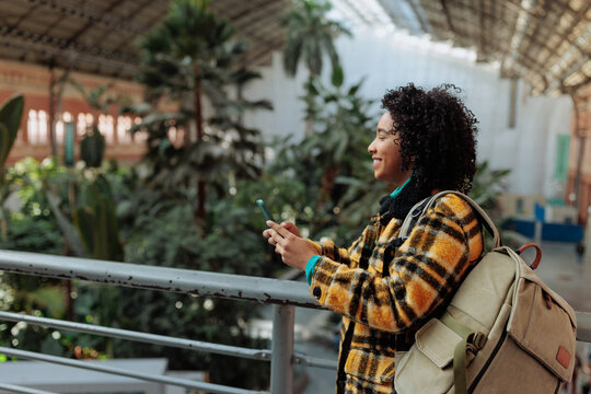 Woman traveler using smartphone in botanical garden station