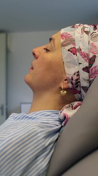 Female patient reclining during oncology treatment session in healthcare center, recovery journey highlighting courage, determination, healing and emotional strength