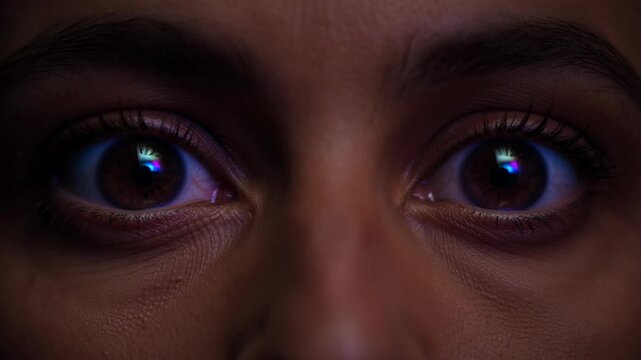 Close-up extreme macro shot of a human eye reflecting digital light and changing color