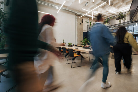 Employees rushing and moving quickly in modern office
