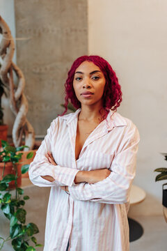 Young woman with pink hair standing confident