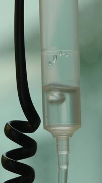 Medical infusion chamber containing therapeutic fluid during treatment session, healthcare detail highlighting recovery, healing, clinical precision and patient support