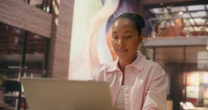 360 Degree. Black Woman Types on Laptop in Stylish Office, Researching Ecommerce Trends, Writing Business Strategy and Driving Digital Productivity Forward. Orbital Cinematic Arc Tracking Shot.