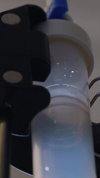 Falling fluid droplets inside medical drip chamber during intravenous treatment, healthcare detail highlighting recovery, patient support, clinical care and healing
