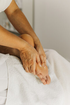 Close up of foot massage therapy session. Female massage therapist's hands.