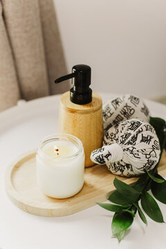 Still life of luxury spa essentials. A bottle with a massage oil and candle on a table.