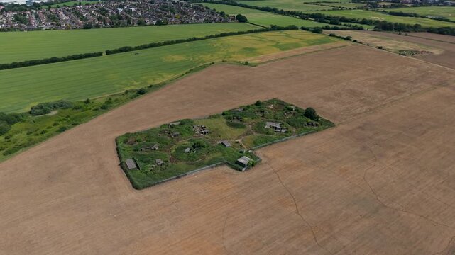 WWII gun emplacement ZE1 wide orbit over Chadwell Heath anti-aircraft battery by Whalebone Lane, Essex, showing wartime concrete pads, earthworks and overgrown ruins.