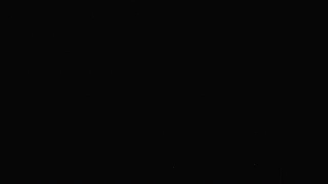 Intense lightning bolt streaks across a dark sky, illuminating silhouetted power lines in this dramatic, static night storm footage. Perfect for weather themes.