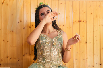 Fototapeta premium Emotional quinceanera wiping tears during family celebration
