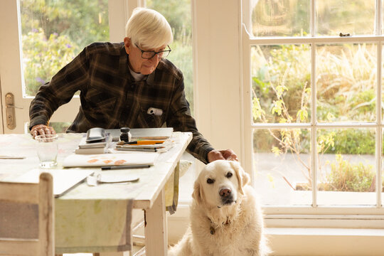 elderly man with his English cream golden retriever dog at home