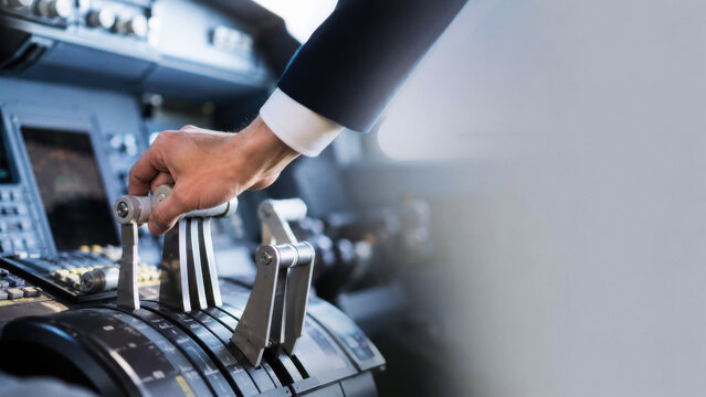 A pilot's hand adjusting the throttle controls in an aircraft cockpit. Focus on aviation and flight operations.