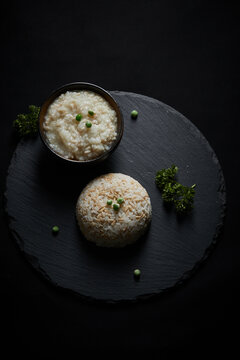 Oat groats and steamed oat rice laid out on a black bluestone slab