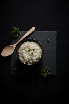 Oat groats and steamed oat rice laid out on a black bluestone slab