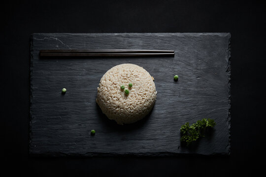 Oat groats and steamed oat rice laid out on a black bluestone slab