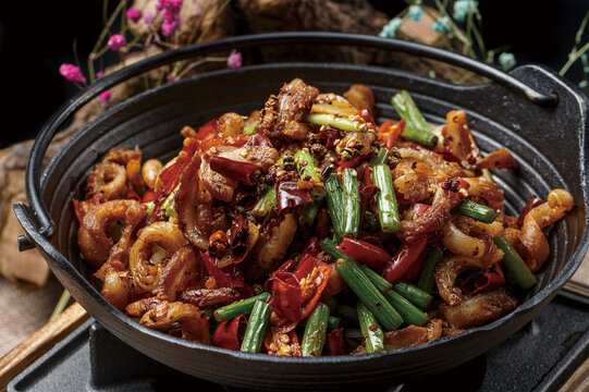 Hot pot with fresh mushrooms and tendons in a black iron pot