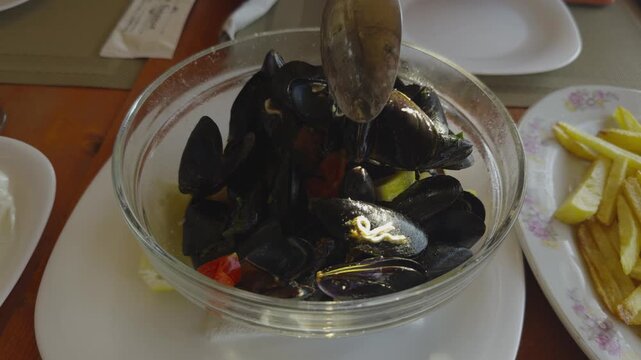 Eating Cooked Mussels. Seafood Dish With Vegetables And Lemon Slices. Mediterranean Cuisine