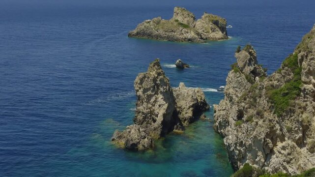 High Rocky Cliffs And Large Stone Formations Rising From Deep Blue Sea Water. Coastal Landscape. Turquoise Sea 
