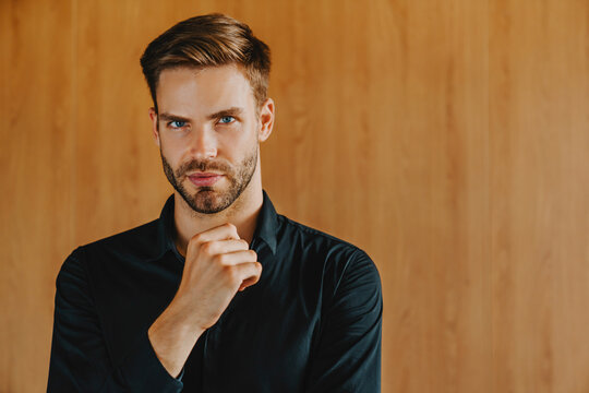 Handsome business man with serious face and hand on chin looking thoughtful, corporate professional thinking about strategy, problem solving, leadership and business planning concept
