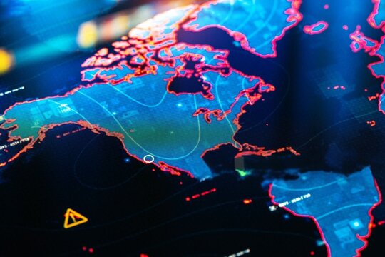 Vibrant digital map glows with dynamic blue and red hues. Complex network lines trace global connections across continents. Faint warning symbols hint at data-driven risks or alerts