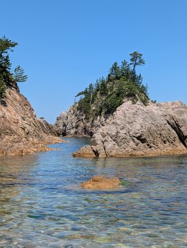 浦富海岸の荒々しい岩肌の間から見えるエメラルドグリーンの海と島