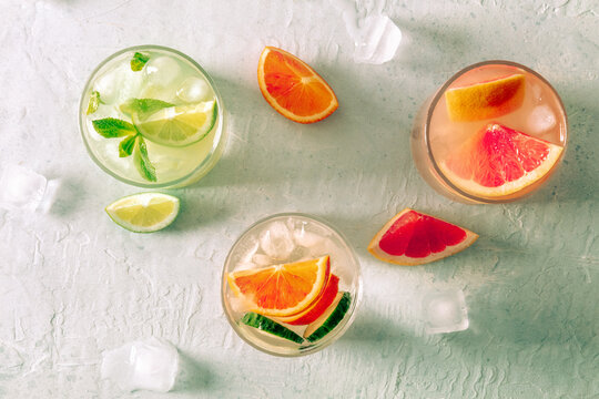 Refreshing summer cocktails with ice cubes on a light background