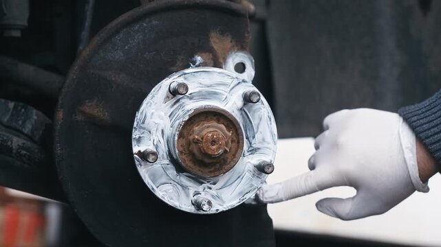Coating wheel hub mating surface with graphite anti seize compound during brake service. Corrosion protection preparing metal contact area for easier future disassembly. DIY automotive maintenance