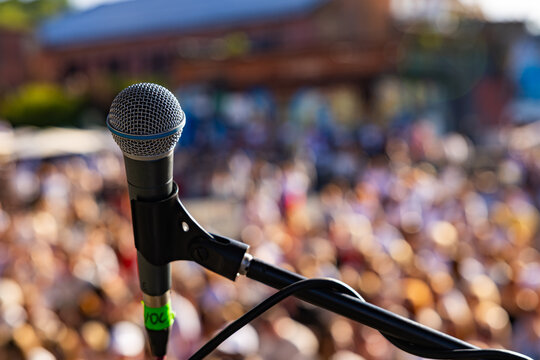 rofessional vocal microphone close up on live concert stage with blurred crowd background