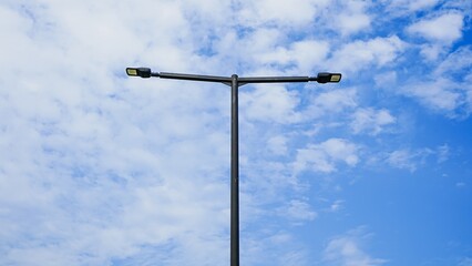 Obraz premium Modern double-headed LED street light against bright blue sky.