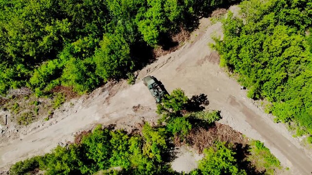 Aerial drone view of a mobile geotechnical drilling rig conducting soil investigation and ground sampling at a future construction site near a forested area in Sumy, Ukraine. The specialized drilling 