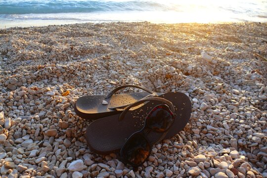 Flip flop sandals and sun glass on the beach by the blue sea summer beach accessories