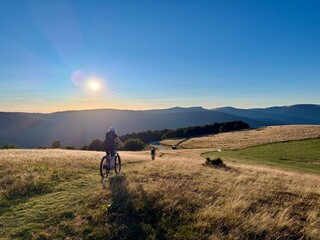 Mountain bikers riding across the golden high pastures © Mickaël LEBRET