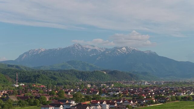 Aerial ascending over Cristian and Rasnov towns to Bucegi Mountains