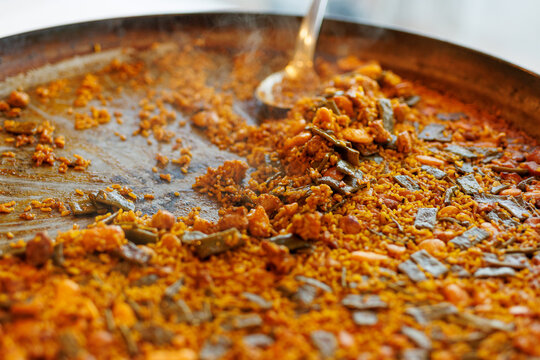Traditional Spanish paella rice cooking in large pan