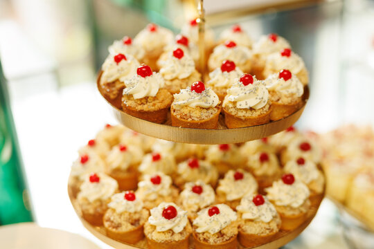 Tiered Stand of Mini Cupcakes with Cream and Cherries