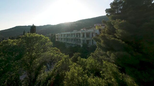 Aerial Drone Shot of Abandoned Sanatorium Hospital Reveal Behind Trees in Nature Forest Near Kavala Greece