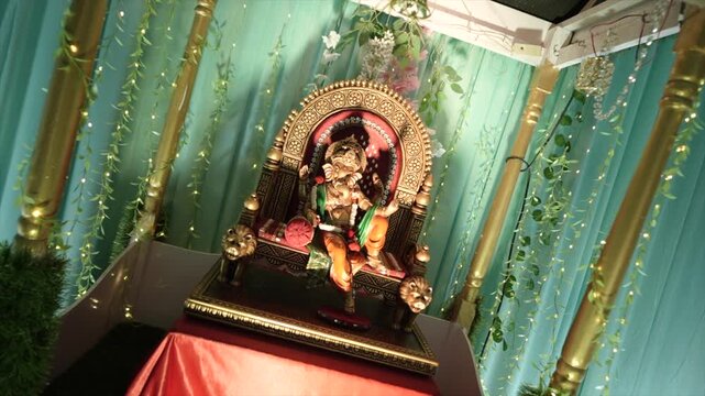Dynamic angle of a golden Lord Ganesha statue resting on an ornate wedding mandap, radiating divine blessings, prosperity, elegance, and spiritual significance.