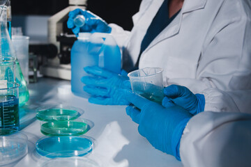 Fototapeta premium Female and Male Scientists Working on their Computers In Big Modern Laboratory. Various Shelves with Beakers, Chemicals and Different Technical Equipment is Visible.