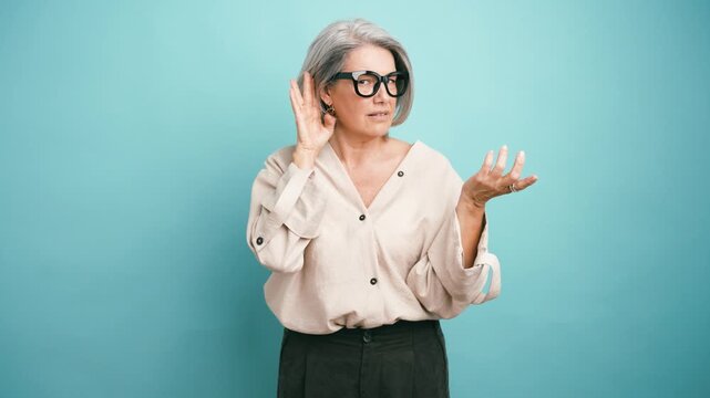 Older woman with grey hair holding her hand to her ear, trying to listen to gossip. A curious person eavesdropping on a conversation