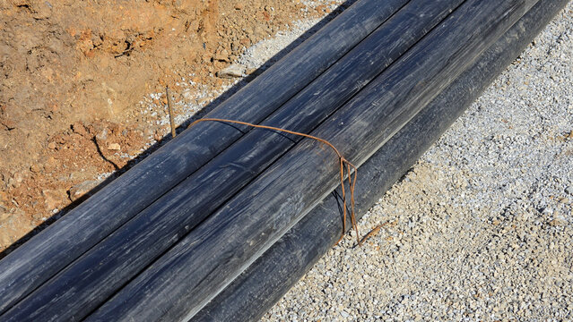 High-density polyethylene conduit pipes tied with steel wire on gravel bedding