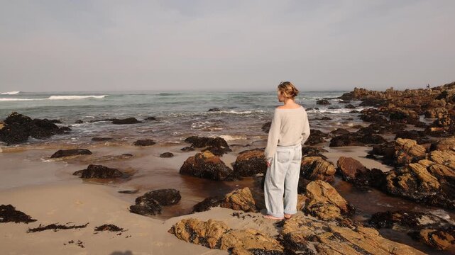 youn woman looking out at sea, Onrus Beach, Onrus, South Africa