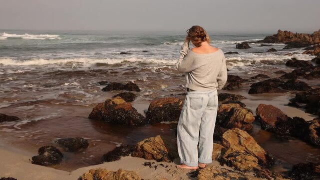 youn woman looking out at sea, Onrus Beach, Onrus, South Africa