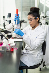 Fototapeta premium Female researcher pipetting liquid in biology laboratory