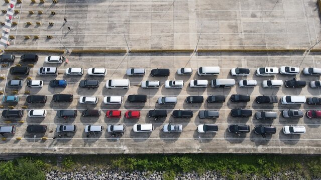 Aerial view of the Bakauheni ferry terminal parking area with rows of vehicles waiting for boarding in Bakauheni, Lampung, Indonesia.