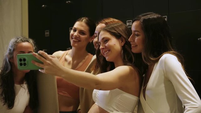 Happy women in sportswear taking a selfie together after a yoga class in the locker room